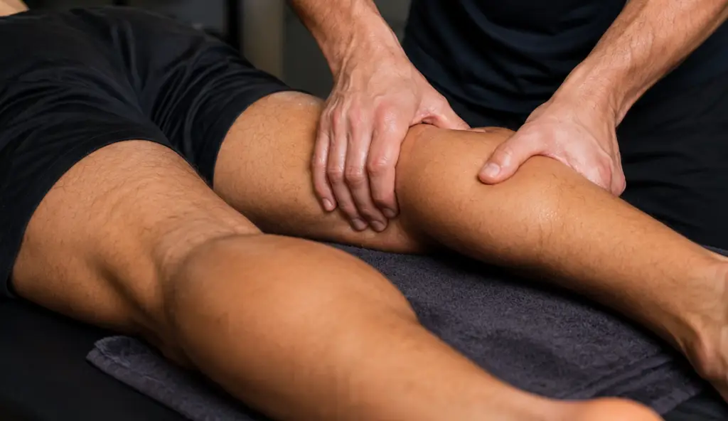 Sports massage therapist working on athlete's calf muscle