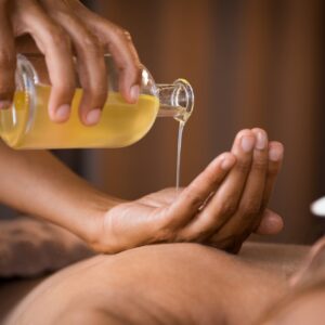 Therapist pouring massage oil at spa