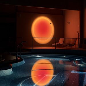 Indoor spa pool with a sunset-like light reflection, creating a relaxing atmosphere.