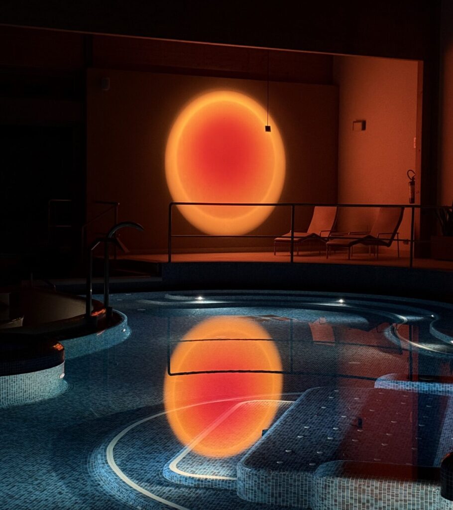 Indoor spa pool with a sunset-like light reflection, creating a relaxing atmosphere.