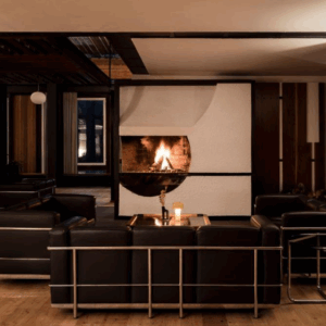 Day SPA & Night - Infra: Modern lounge with black leather couches, fireplace, and wood paneling, perfect for luxury relaxation.