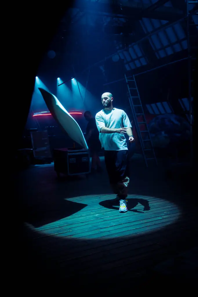 Man in spotlight on stage, preparing for Aufguss ritual